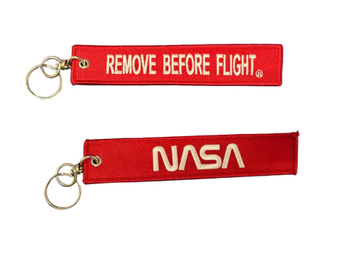 Red keychains with 'Remove Before Flight' in front and NASA Worm logo on back.